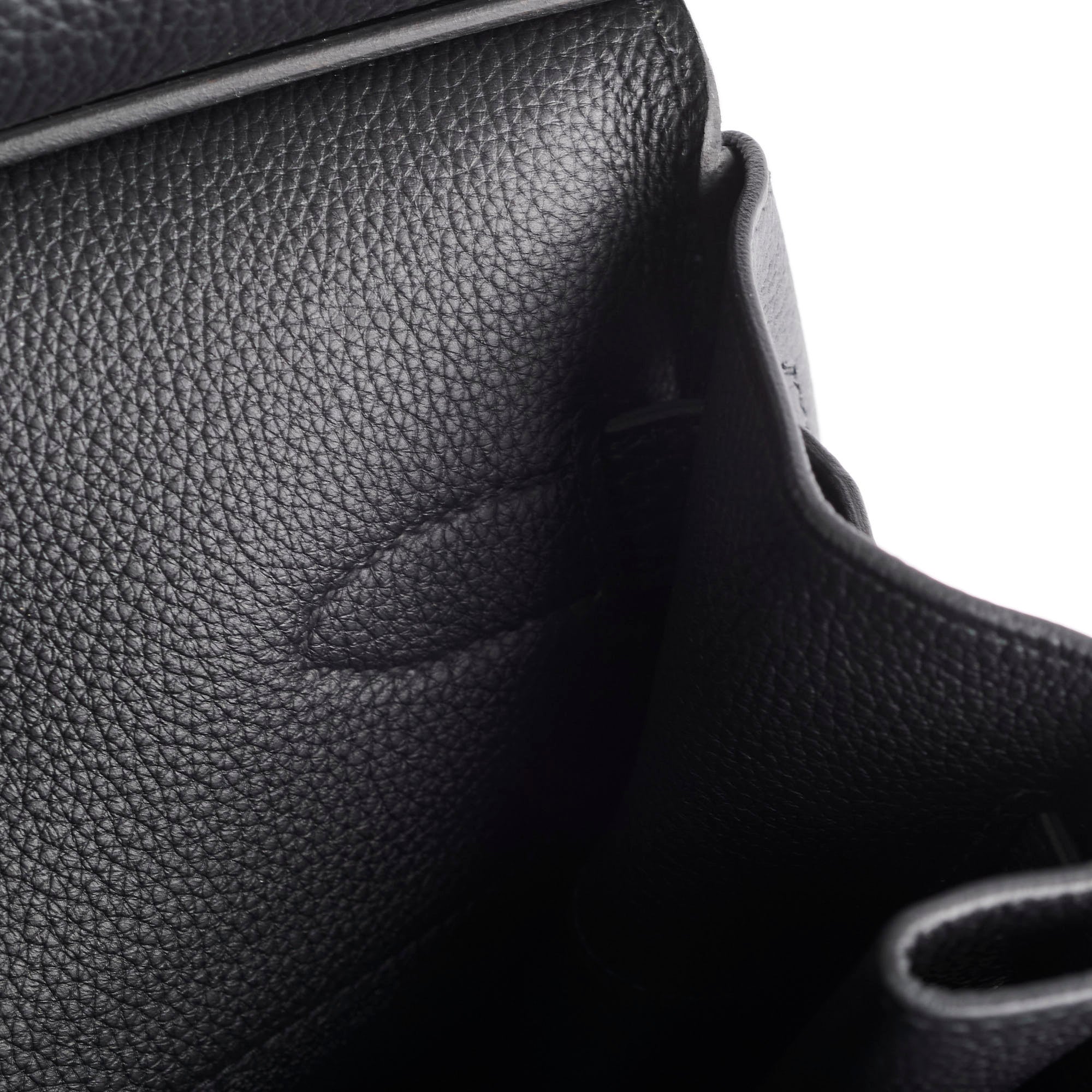 Close-up of a black leather car seat with visible stitching