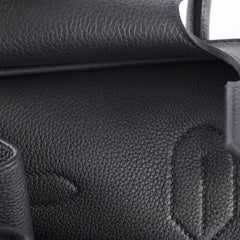 Close-up of a black leather handbag with visible branding.