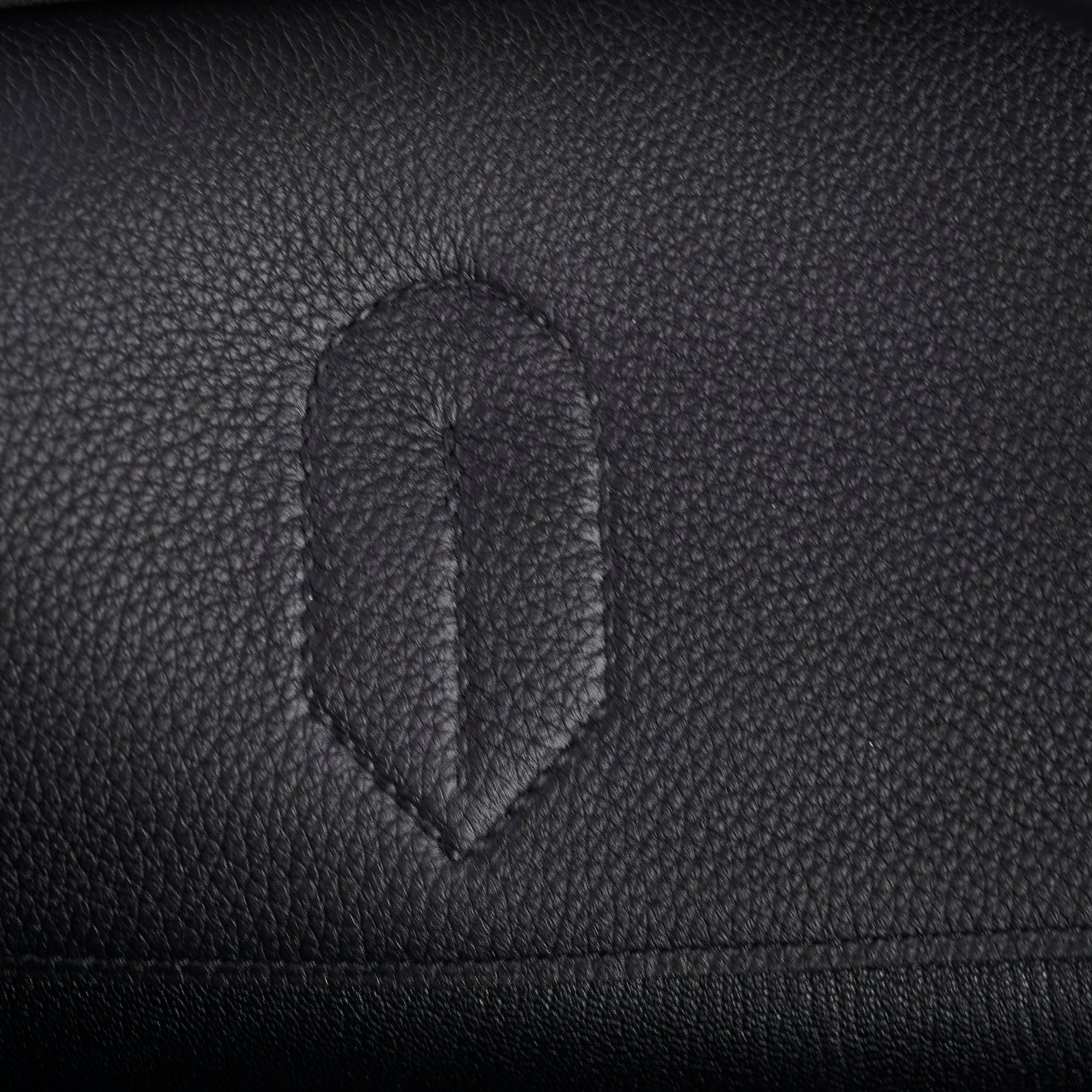 Close-up of a black leather surface with a subtle embossed design.