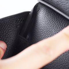 Close-up of a hand holding a black leather wallet.