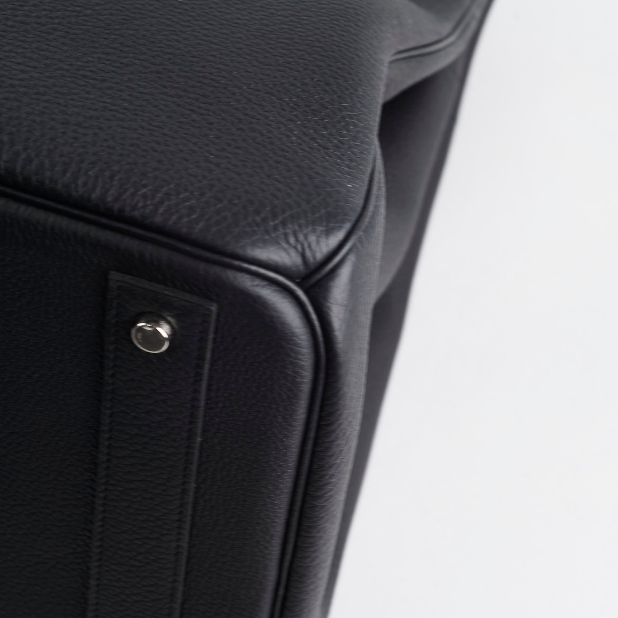 Close-up of a black leather product with a metallic accent 