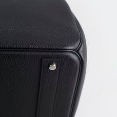 Close-up of a black leather product with a silver button 