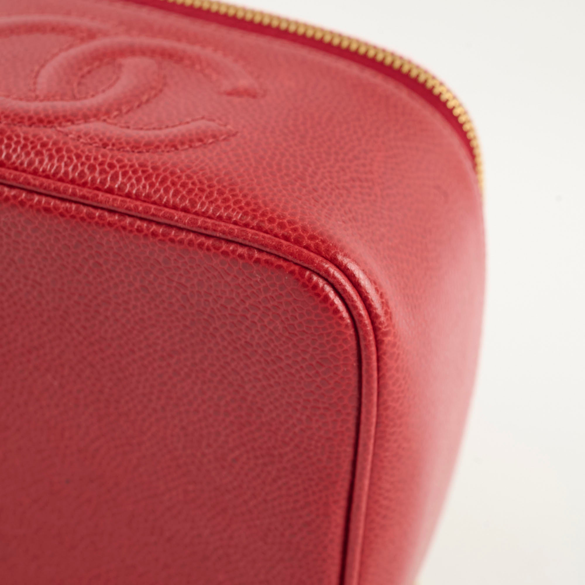 Close-up of a red leather product with a gold zipper