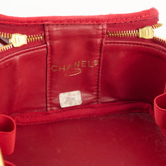 Close-up of a red Chanel handbag with gold zipper.
