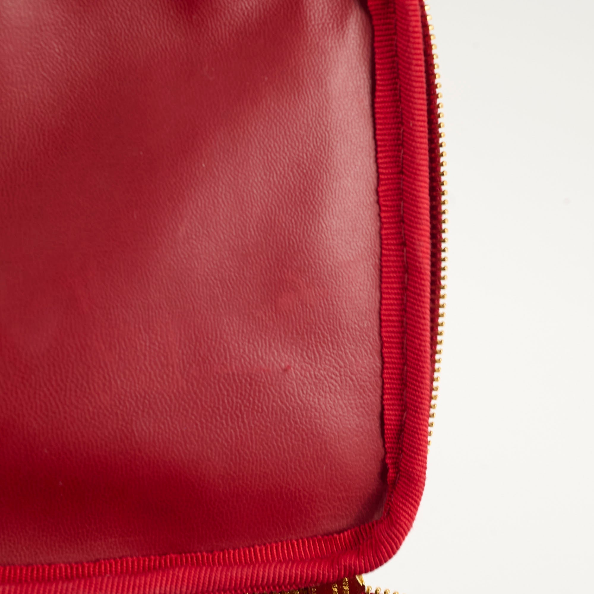 Close-up of a red leather pouch with a gold zipper 