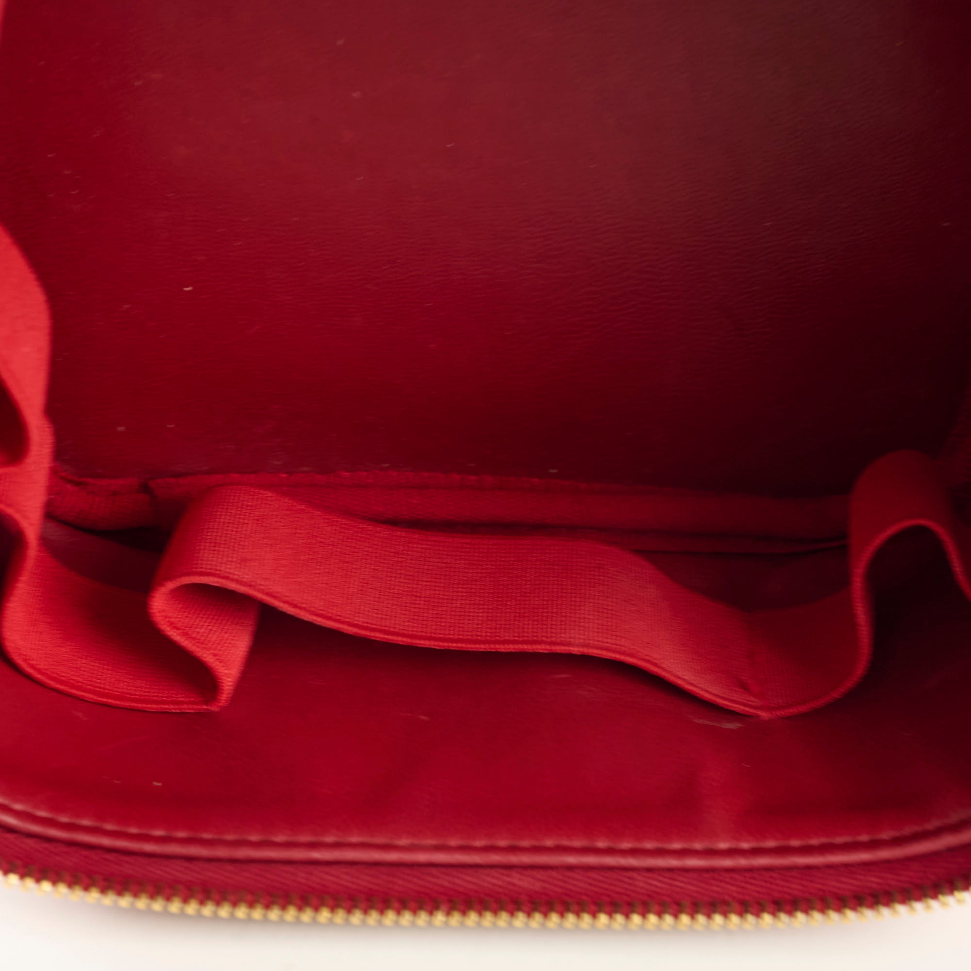 Close-up of a red fabric surface with a gold zipper.