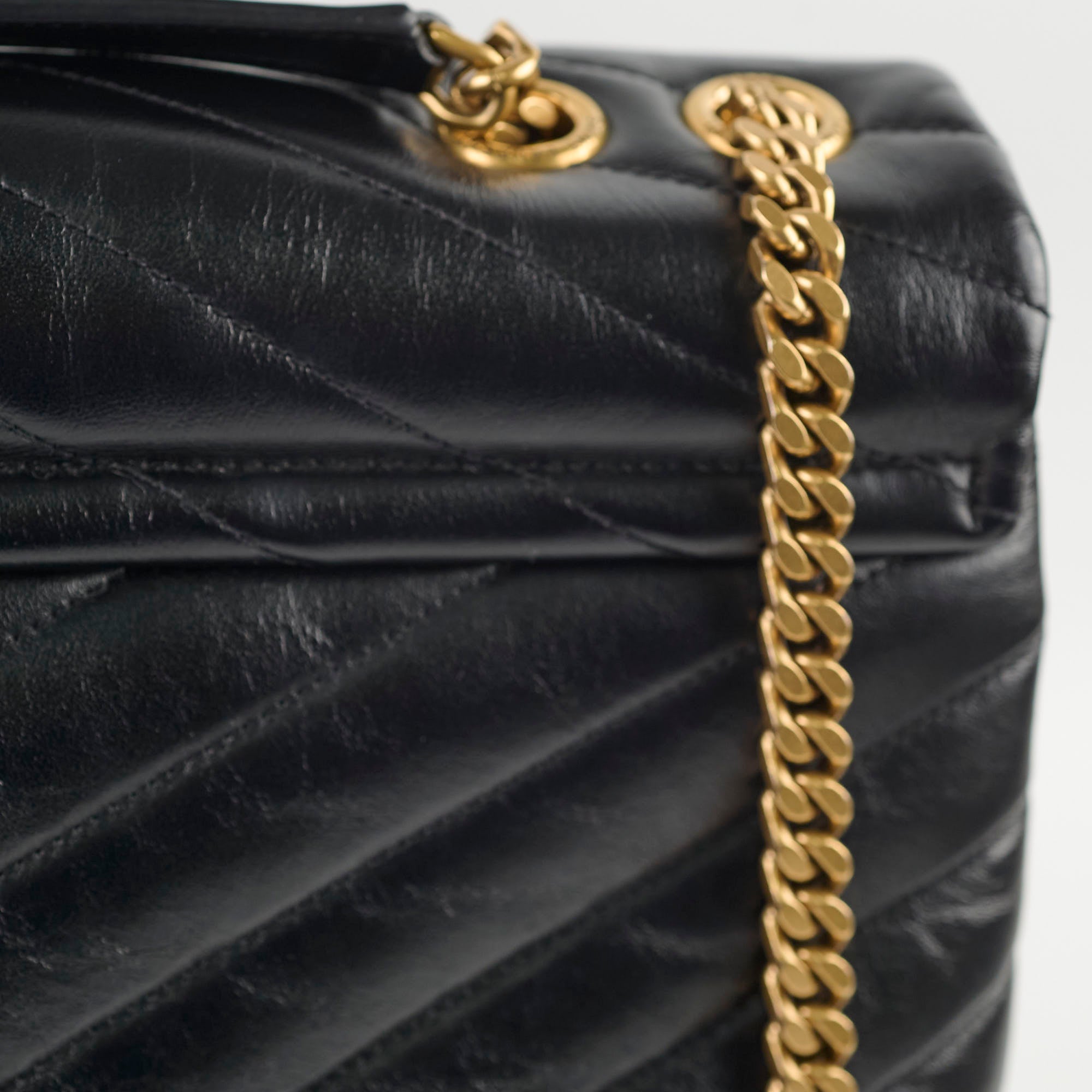 Black quilted handbag with a gold chain strap 