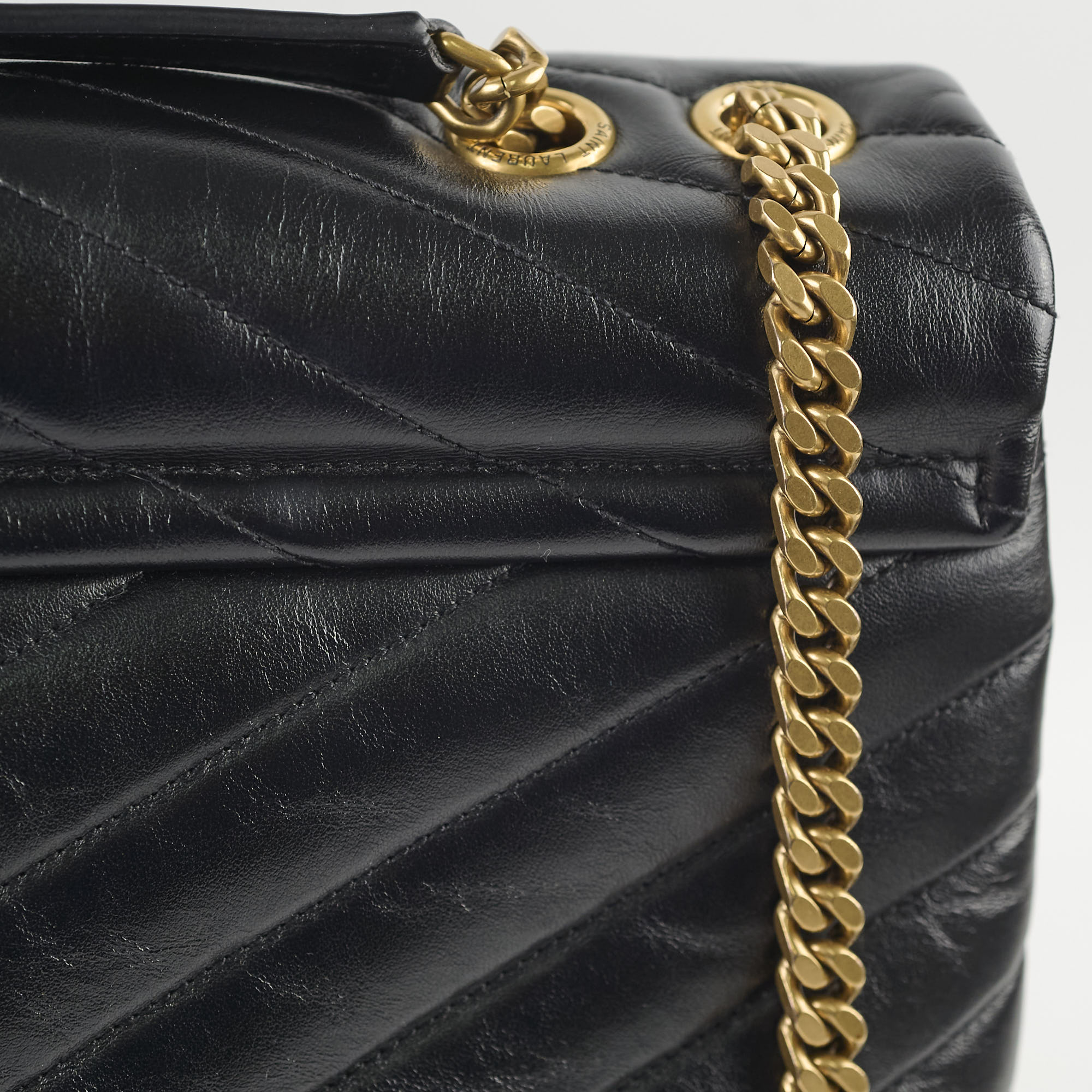 Black quilted handbag with a gold chain strap 