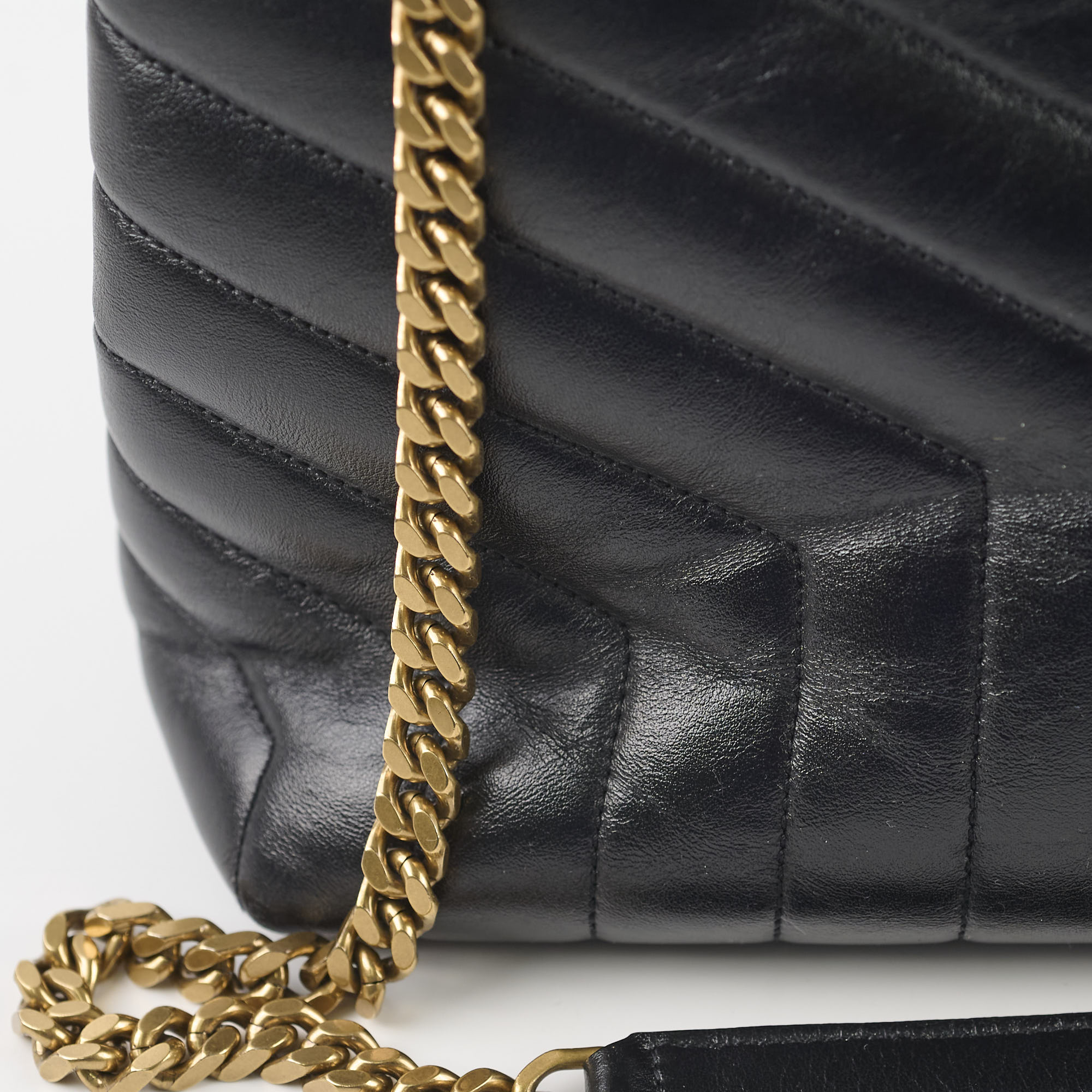 Black quilted handbag with a gold chain strap 