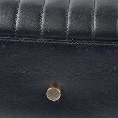 Close-up of a black leather bag with a gold clasp.