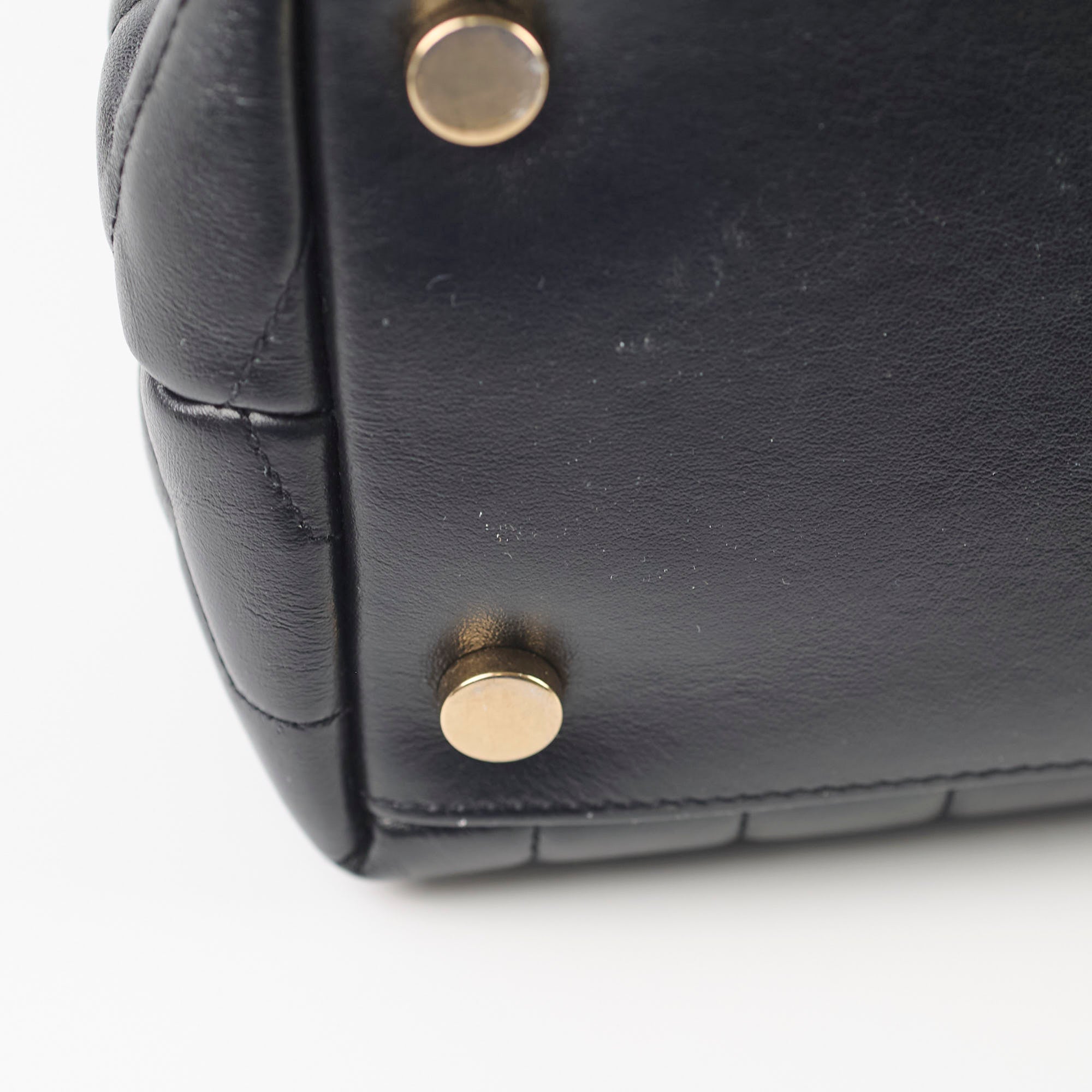 Close-up of a black leather bag with gold studs