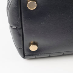 Close-up of a black leather bag with gold studs