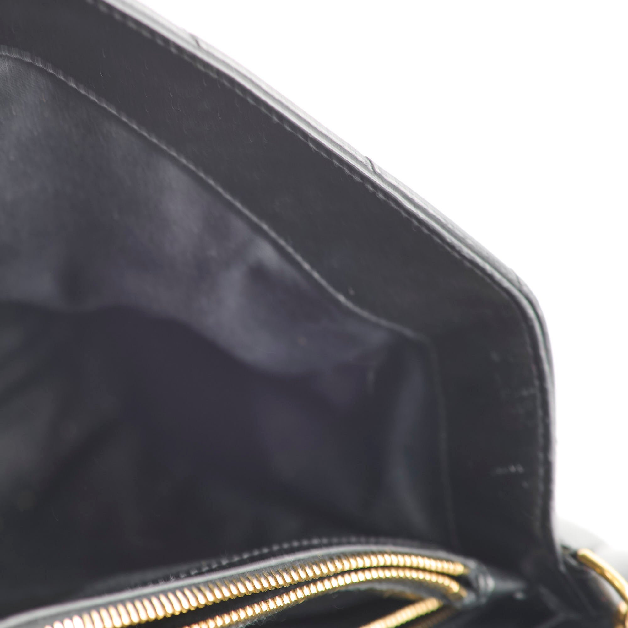 Close-up of a black bag with a gold zipper 