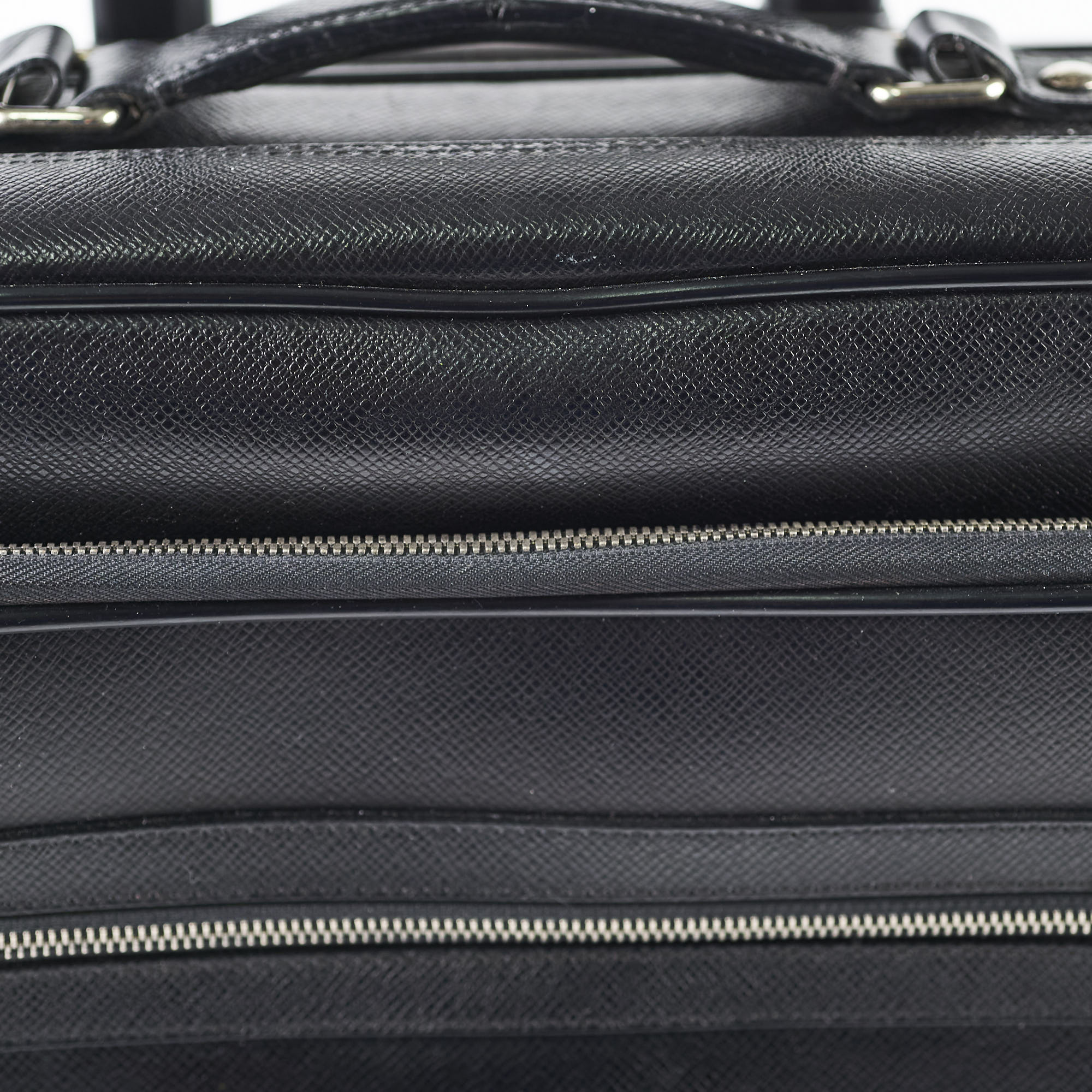 Close-up of a black textured bag with zippers