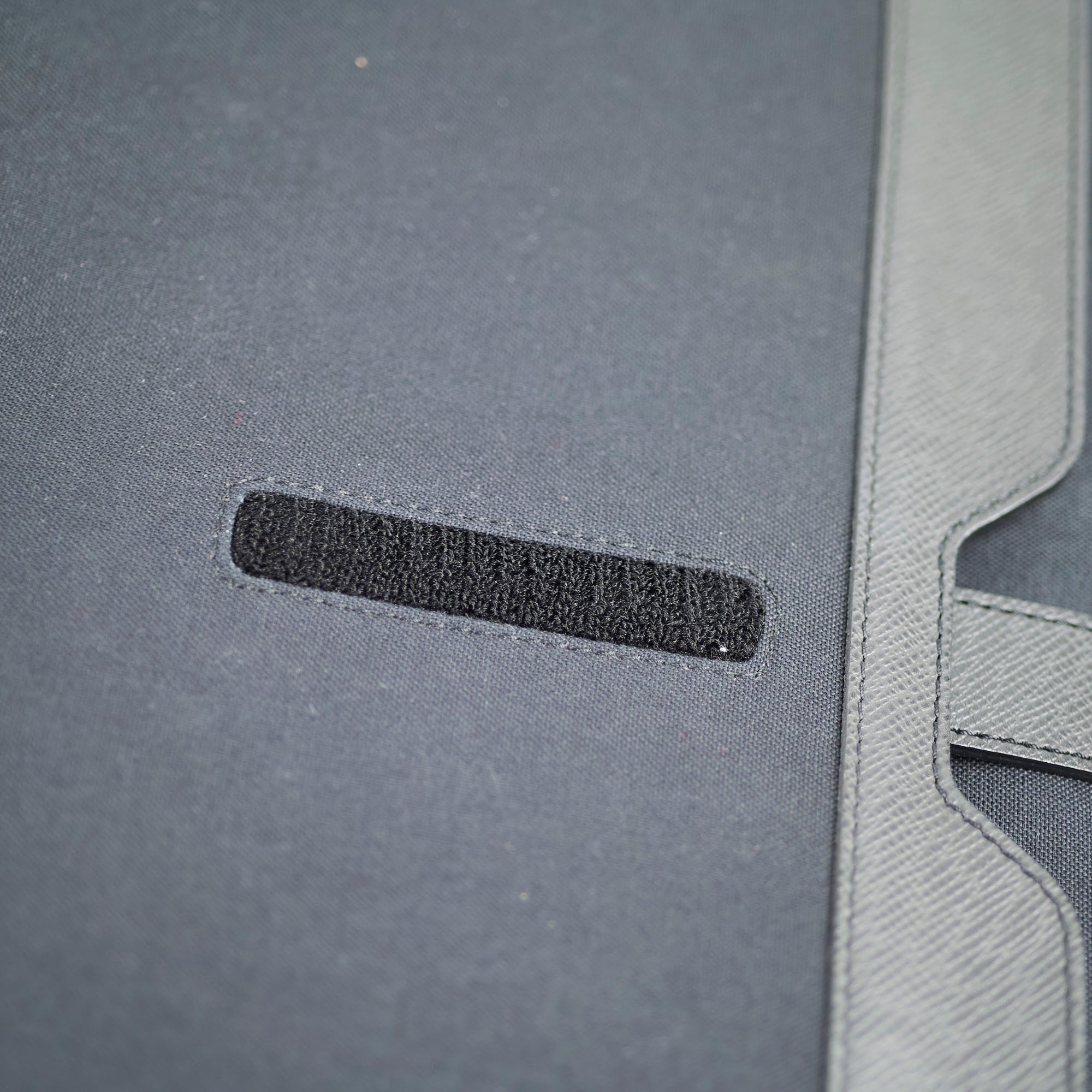 Close-up of a gray textured surface with a black strip