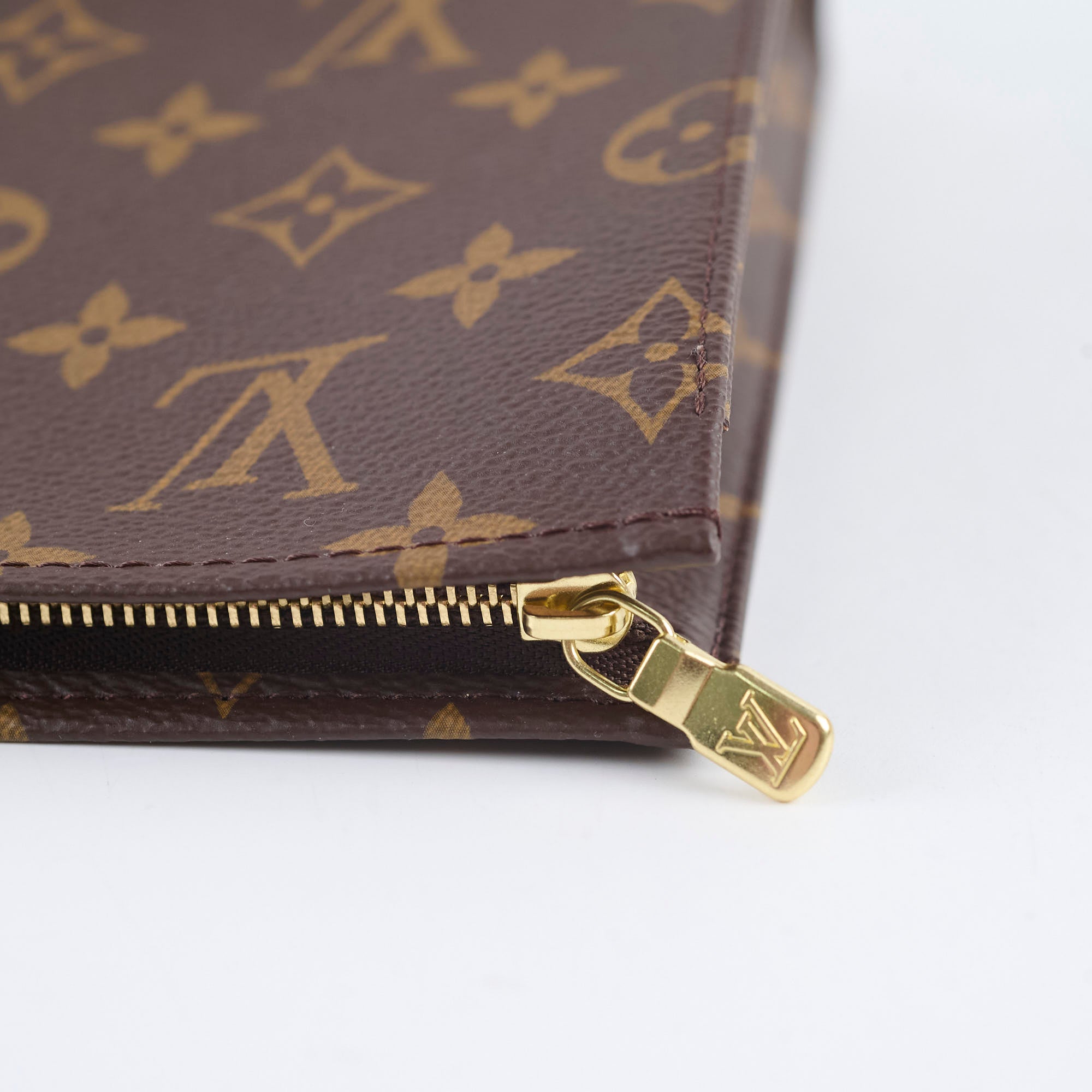 Close-up of a brown wallet with gold zipper and logo 
