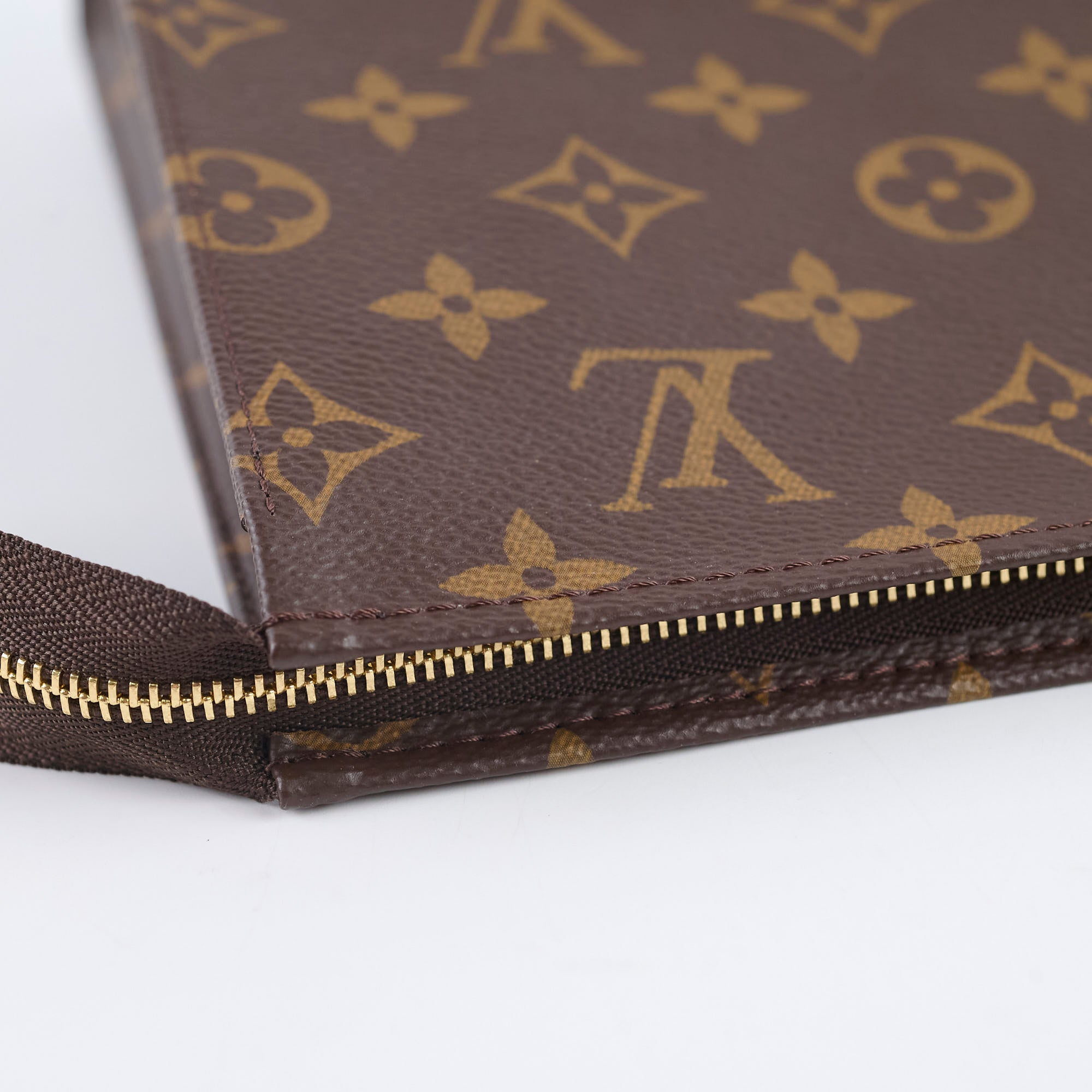 Close-up of a brown leather wallet with gold zipper and logo 